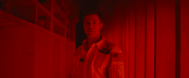 Brad Pitt stands in a red room in a scene from "Ad Astra"